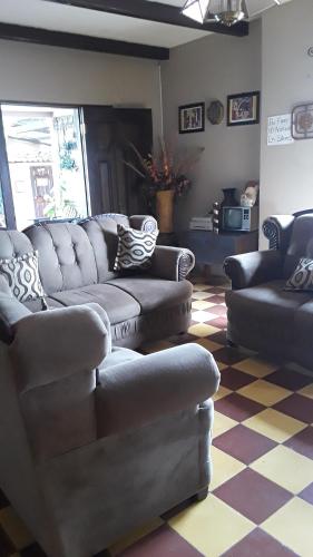 uma sala de estar com sofás e um piso em xadrez em HOTEL EL ALMENDRO em Copán