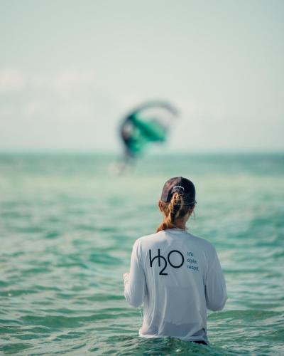 a woman standing in the water in the ocean at H2O LifeStyle Resort in Long Bay Hills