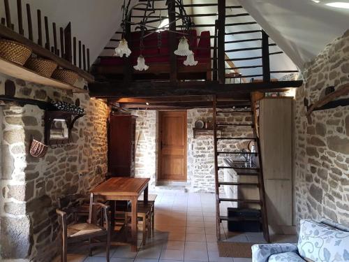 ein Esszimmer mit einem Holztisch und einer Treppe in der Unterkunft Le Four de La Jugie in Le Lonzac