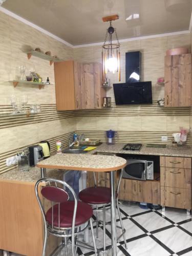 a kitchen with two bar stools and a counter top at Apartments on Kashyns'koho Street 6 in Myrhorod