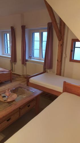 a room with two beds and a table at Pension Styl in Bedřichov