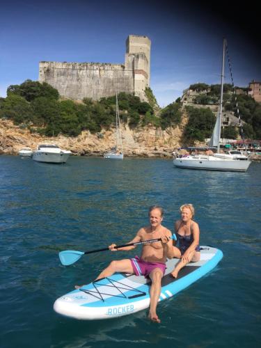 a man and a woman on a paddle board in the water at Marinella House in Sarzana