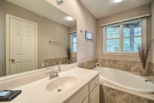 a bathroom with a sink and a bath tub and a window at Coastal Home with Community Pool Less Than 2 Miles to Beach! in Corolla