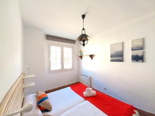 - une chambre avec un lit et une couverture rouge dans l'établissement Plaza Andalucía Edificio Salvia 2-6 pax, à Monachil