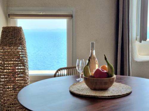 eine Schale Obst auf einem Tisch mit einem Weinglas in der Unterkunft Mare è rocca in Bonifacio
