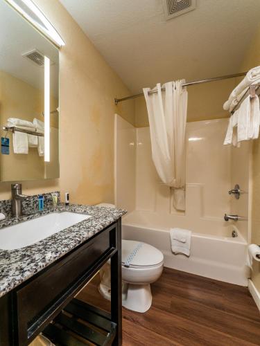 a bathroom with a tub and a toilet and a sink at Microtel Inn and Suites Ocala in Ocala