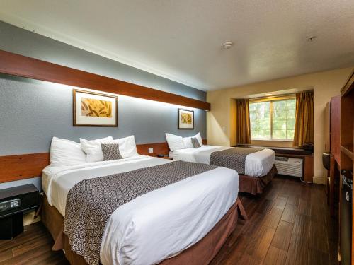 a hotel room with two beds and a window at Microtel Inn and Suites Ocala in Ocala