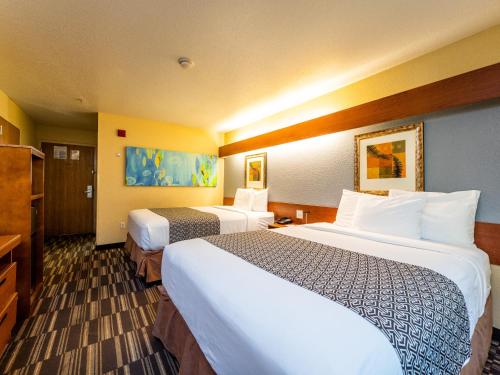 a hotel room with two beds and a television at Microtel Inn and Suites Ocala in Ocala