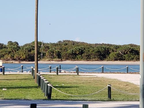 a beach with a fence and a body of water at Townhouse Apartment b in Fort Pierce