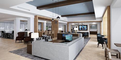 a lobby with a couch and chairs and a television at Staybridge Suites - Cincinnati East - Milford by IHG in Cincinnati