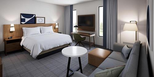 1 dormitorio con cama, escritorio y sofá en Staybridge Suites - Cincinnati East - Milford, an IHG Hotel en Cincinnati