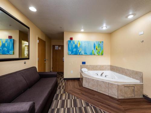 Microtel Inn and Suites Ocala في أوكالا: غرفة معيشة مع أريكة وحوض استحمام