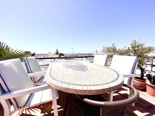 a patio table and chairs on a balcony at Zenit Budget Basicinn Olhao in Olhão