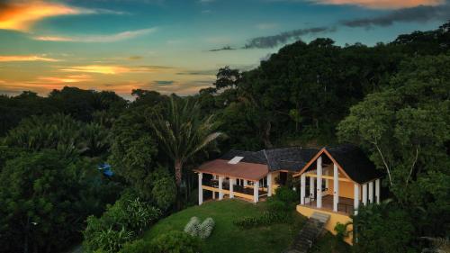a house on top of a hill with trees at Casa Varuna - 2 Bedrooms in West End