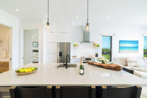 a kitchen with a island with a bowl of fruit on it at H2O LifeStyle Resort in Long Bay Hills