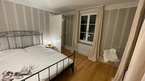 1 dormitorio con cama blanca y ventana en Schwendi-Blueme en Heiligenschwendi