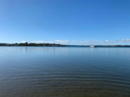 a large body of water with a boat in it at Cabañas y Tinajas Rio Quenuir in Maullín