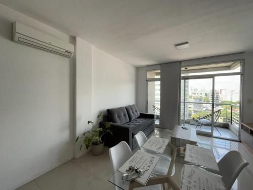 uma sala de estar com um sofá, uma mesa e cadeiras em Apartamento 2 Ambientes - Moderno totalmente Amoblado em Buenos Aires
