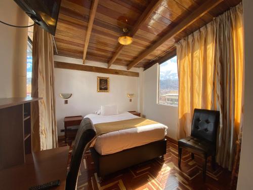 1 dormitorio con cama, ventana y TV en Cusco Golden Perú Inn, en Cusco