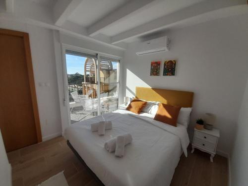 ein Schlafzimmer mit einem großen weißen Bett und einem Balkon in der Unterkunft Costa Blanca Holiday Rental AltaMar I in El Campello