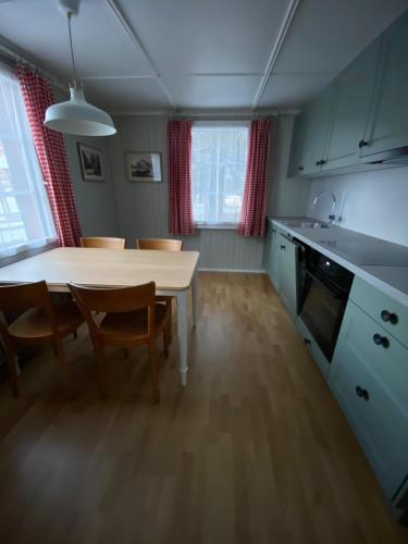 a kitchen with a table and chairs and a table and cabinets at Familienferien im Chalet Bärgli Kandersteg in Kandersteg