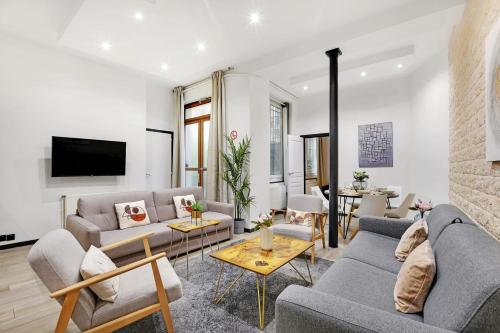 a living room with two couches and a tv at Beautiful flat in the heart of the Marais in Paris