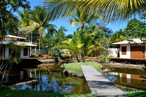 eine Brücke über einen Teich in einem Resort in der Unterkunft Camauí Hotel in Barra Grande
