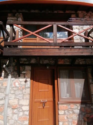 Traditional Stone Cottage in Palio Elatohori في إلاتوشوري: مبنى فيه باب خشبي ونوافذ