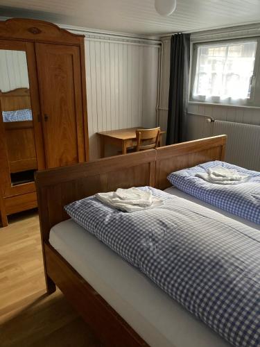 a bedroom with two beds and a table in it at Familienferien im Chalet Bärgli Kandersteg in Kandersteg