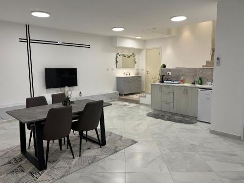 a kitchen with a table and chairs in a room at Golan Zimmer - צימר הגולן in Mas'ade