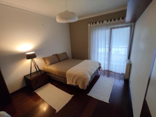 ein kleines Schlafzimmer mit einem Bett und einem Fenster in der Unterkunft A Casa de São Pedro de Moel in São Pedro de Muel