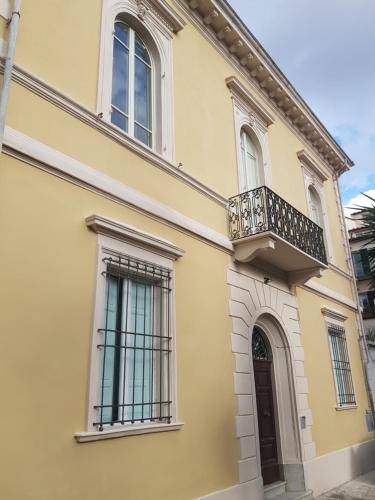 een geel huis met een balkon en een deur bij PALACE COMFORT INN in Pisa