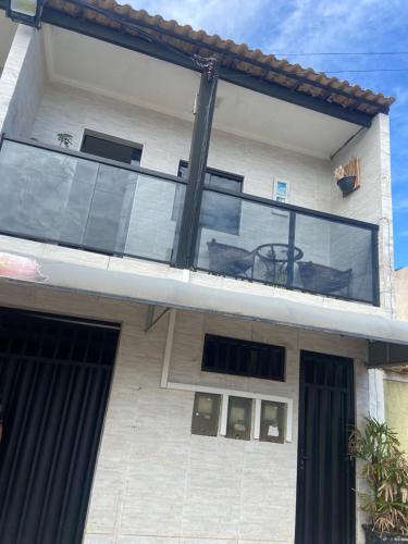 a house with a glass balcony with a table on it at Apartamentos da praia in Arraial do Cabo