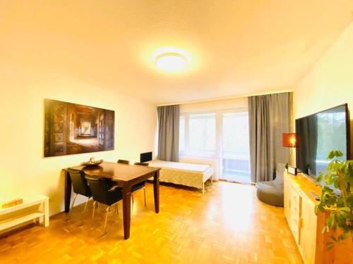 a living room with a table and a room with a bed at HannoverMesseApartment 2 bedroom, Balcony with garden view in Hannover