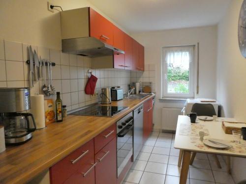 une cuisine avec des placards rouges et un comptoir dans l'établissement Ferienwohnung Wanderparadies Neuwied-Heimbach, à Neuwied