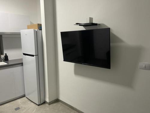 a flat screen tv hanging on a wall in a kitchen at פסגת יובלים in Qiryat Shemona