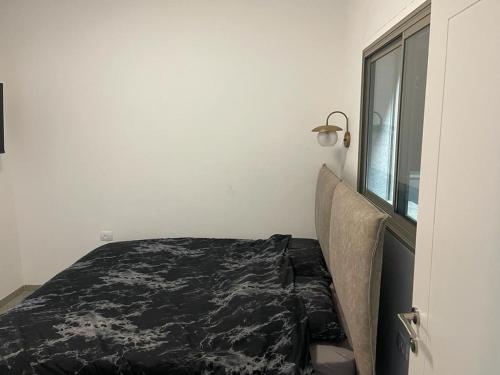 um quarto com uma cama e uma janela em פסגת יובלים em Qiryat Shemona