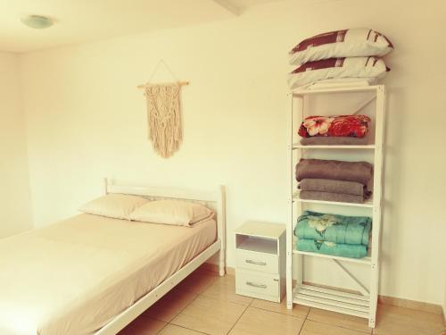 1 dormitorio con cama y estante con toallas en Mountain View, en Curitiba