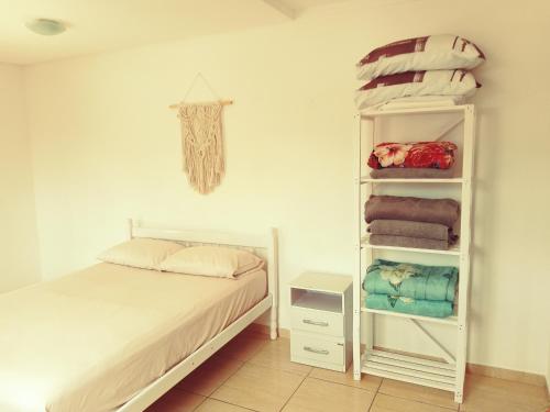 a bedroom with a bed and a shelf with towels at Mountain View in Curitiba