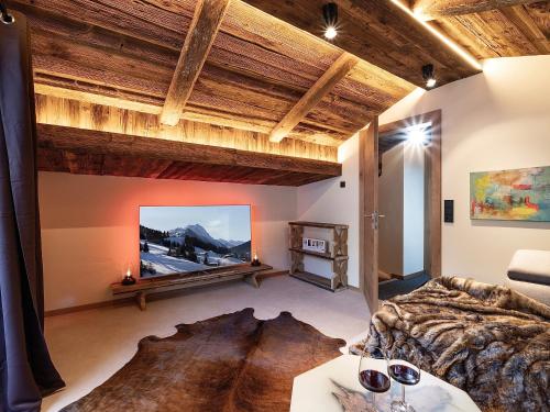 a bedroom with a large bed and a tv at das brunn - Luxus Chalet in Kirchberg in Tirol