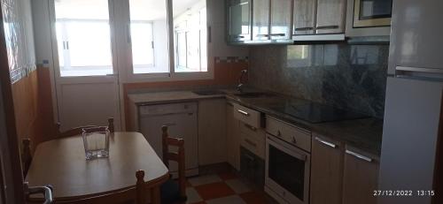 a kitchen with a table and a small kitchen with a table and chairs at Piso Estación in Silleda