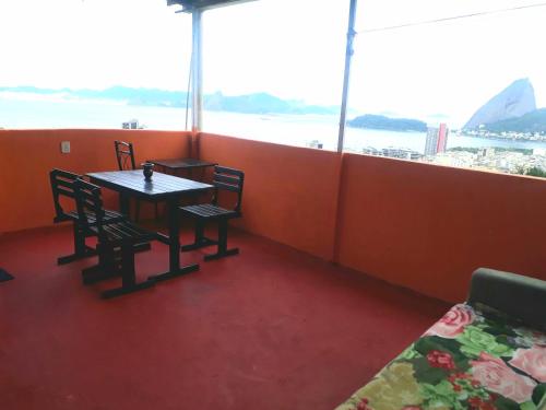 a table and chairs in a room with a view of the ocean at Hostel Tavares Bastos in Rio de Janeiro