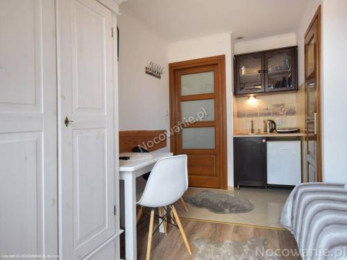 a room with a desk and a bed and a kitchen at Domek z Góralską Duszą Śleboda in Jurgów