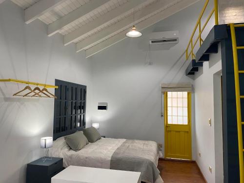 a bedroom with a bed and a yellow door at Departamento Excelente Ubicación. Zona Arístides y Parque. in Mendoza