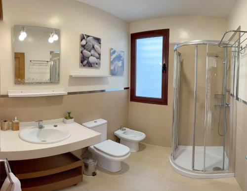 a bathroom with a sink and a toilet and a shower at Villa Los Pinares de Monaco en Roche, Conil, Cádiz in Conil de la Frontera