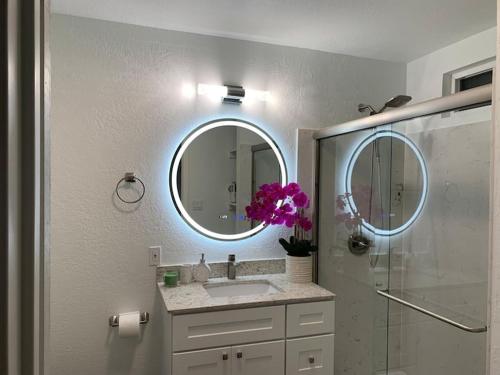 y baño con lavabo, espejo y ducha. en Stylish & Spacious House for Ultimate Relaxation!, en Tracy