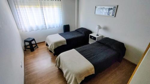 a room with two beds in a room with a window at Confortmdp apartamentos in Mar del Plata