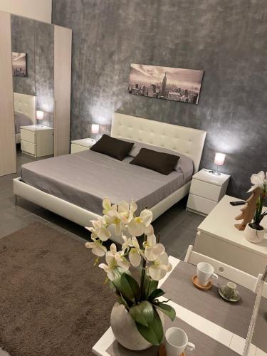 Il CASALETTO di Laura في فيوميتشينو: غرفة نوم بسرير وطاولة مع ورد