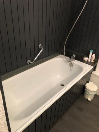 La salle de bains est pourvue d'une baignoire blanche et de toilettes. dans l'établissement Appartement 6 couchages La Foux d’Allos, à Allos