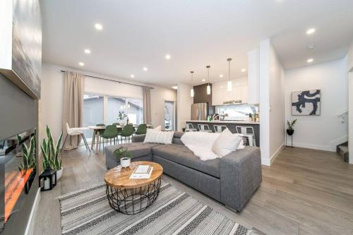 a living room with a couch and a table at Chic Hideaway, 5BR near DT, Fireplace, King Bed, Fast Wifi, Sleeps 13! in Edmonton